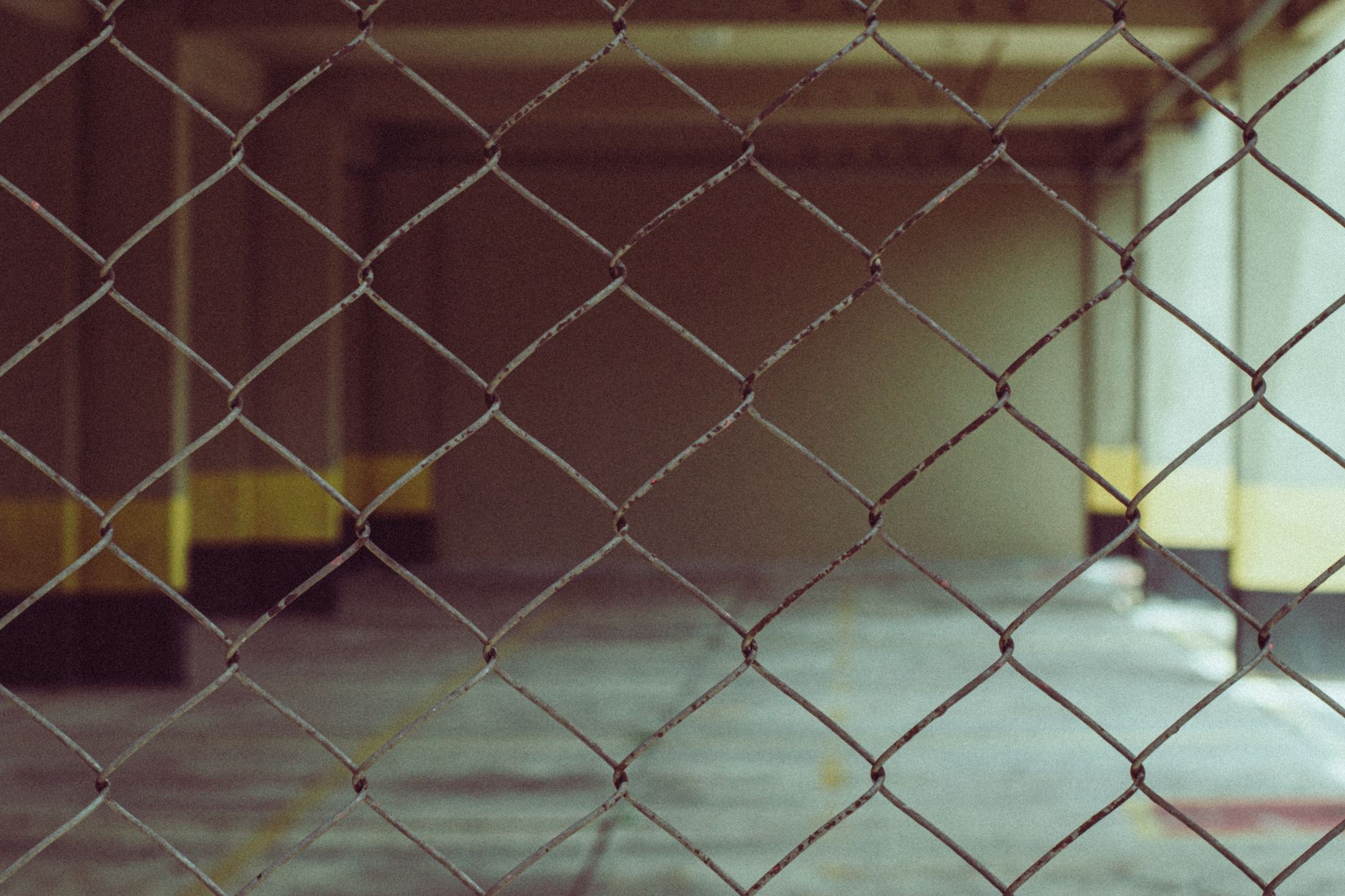 Blurred interior view through a chain link fence in industrial setting in Edmond, OK